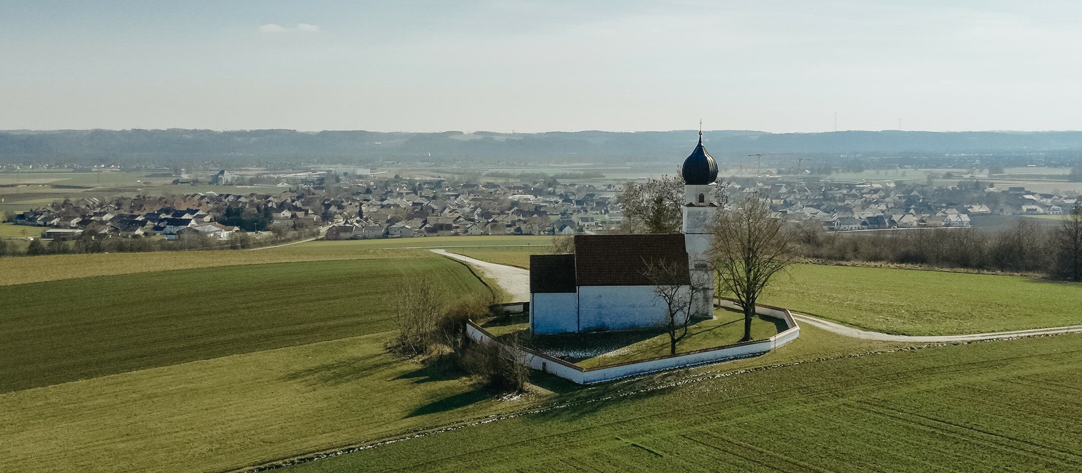 Header_Luftaufnahme Wolfgangskirche Isartal Frühling