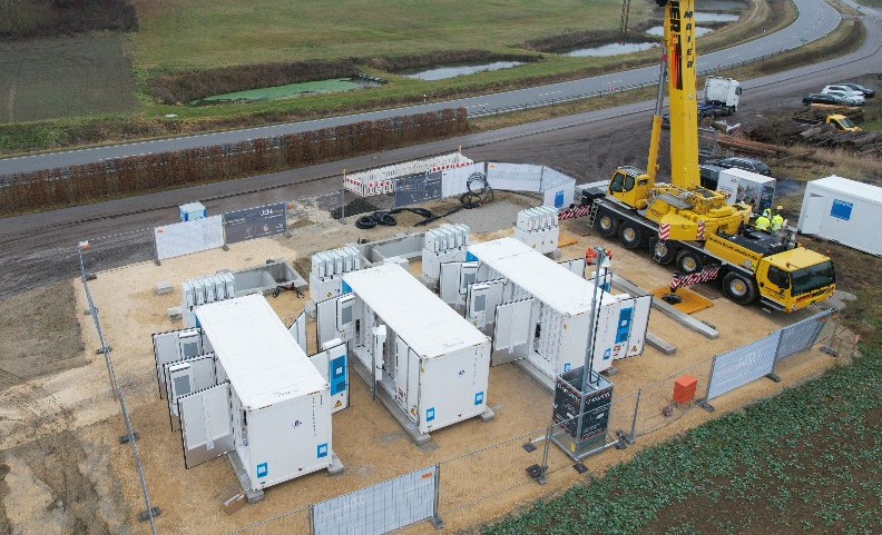 Per Kran werden die Container für den Batteriegroßspeicher in Oberunsbach vom LKW gehoben und aufs Fundament gestellt.