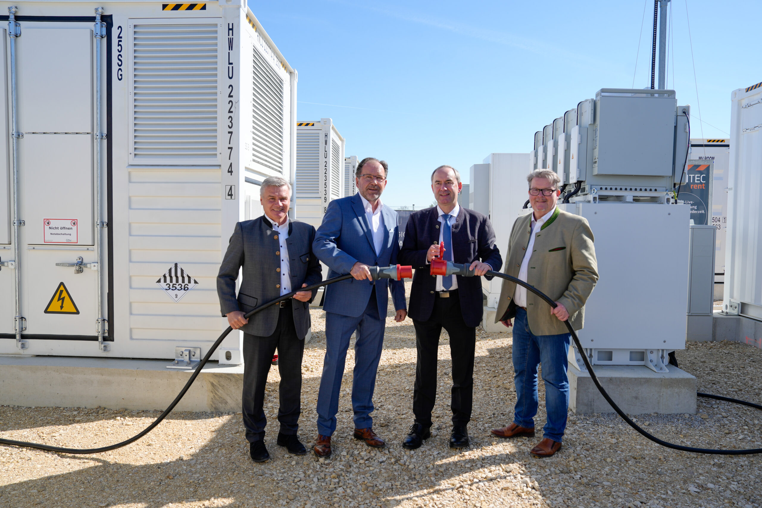 Landrat Peter Dreier, ÜZW Vorstand Micahel Forstner, Energieminister Hubert Aiwanger und Bürgermeister Dieter Neubauer bei der symbolischen Inbetriebnahme des ÜZW Batteriegroßspeichers.